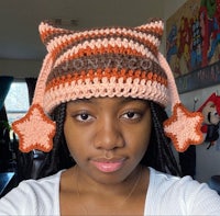 a woman wearing a crocheted cat hat