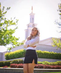 a young woman in a black skirt standing in front of a temple