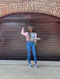 a young woman standing in front of a garage door
