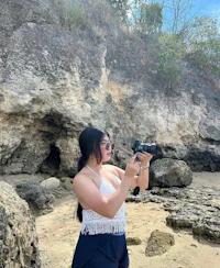 a woman taking a picture with her camera on the beach