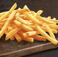a pile of french fries on a wooden cutting board