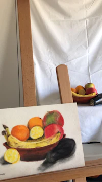 a painting of a bowl of fruit on a easel