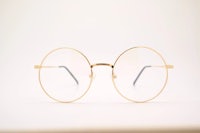 a pair of gold rimmed glasses on a white background