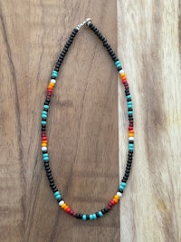a colorful beaded necklace on a wooden table