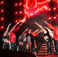 a group of dancers on stage with red lights
