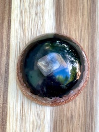 a black stone on top of a wooden table