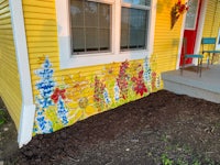 a yellow house with flowers painted on it