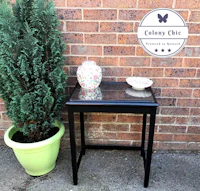 a black side table next to a potted plant