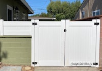 a white fence with a black handle on it