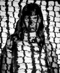 a black and white photo of a girl in a cage