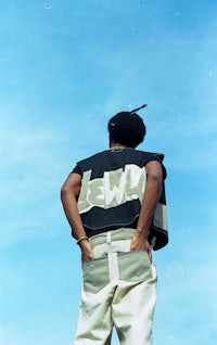 a man is standing on a field with a skateboard