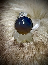 a pendant with a blue opal stone on it