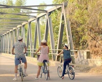 a group of people riding bicycles on a bridge