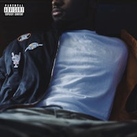 a man in a jacket is laying on a bed