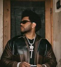 a man in a leather jacket holding a cell phone