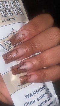 a woman is holding a package of nail polish