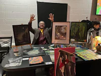 a man standing in front of a table with a lot of art on it