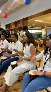 a group of people sitting in chairs and playing drums
