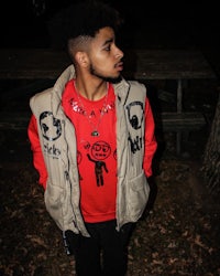 a young man wearing a red vest and a red shirt
