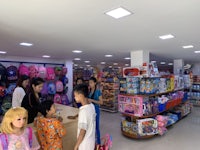 a group of children are standing in a toy store