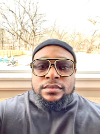 a black man wearing glasses and a hat