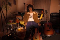 a man sitting on a chair next to a guitar