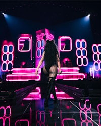 nicki minaj performs on stage with neon lights