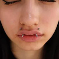 a close up of a woman with piercings on her nose