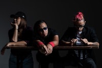 a group of people sitting at a table with pink hair