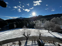 the sun is shining on a snow covered field
