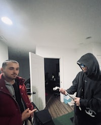 two men standing next to each other in a living room