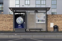 a bus stop next to a brick building