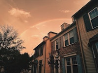 a rainbow in the sky over a house