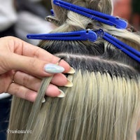 a person cutting a person's hair with blue clippers