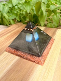 a small pyramid with blue stones on top of a wooden table