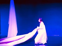 a woman in a white dress holding a white cloth