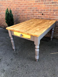 a grey table with a wooden top and drawers