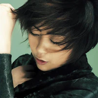 an asian woman with her hair pulled back in a black jacket