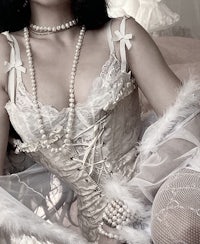 a woman in a white corset sitting on a bed