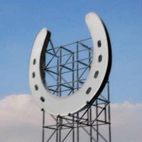a horseshoe sign on top of a metal pole