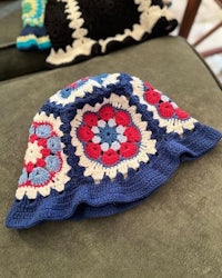two crocheted hats sitting on a couch
