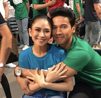 a man and woman hugging in front of a crowd