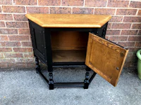 a black and wood corner cabinet with a door open