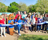 a group of people standing in front of a blue ribbon
