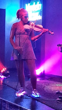 a woman playing a violin on stage