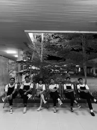 black and white photo of a group of people sitting on a bench