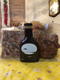 a bottle of bbq sauce and meat on a table