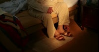 a man sitting on a bed at night