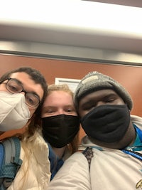three people wearing face masks in an elevator