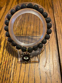 a black lava bead bracelet on a wooden table